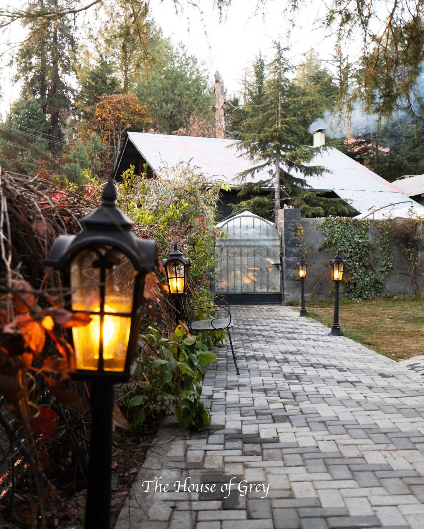 House of Grey exterior pathway with stone walls and warm lighting